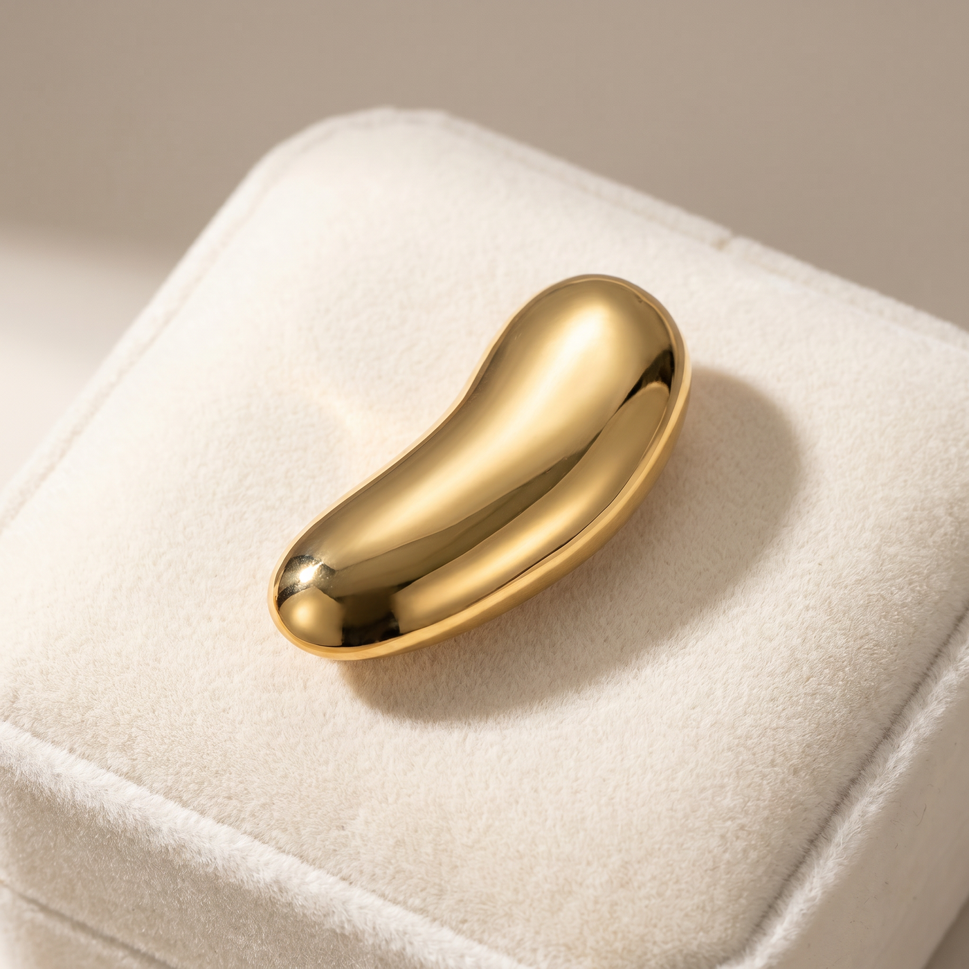 Broche Haricot en acier, bijou vintage Alyvoa présentée sur un coussin · Doré