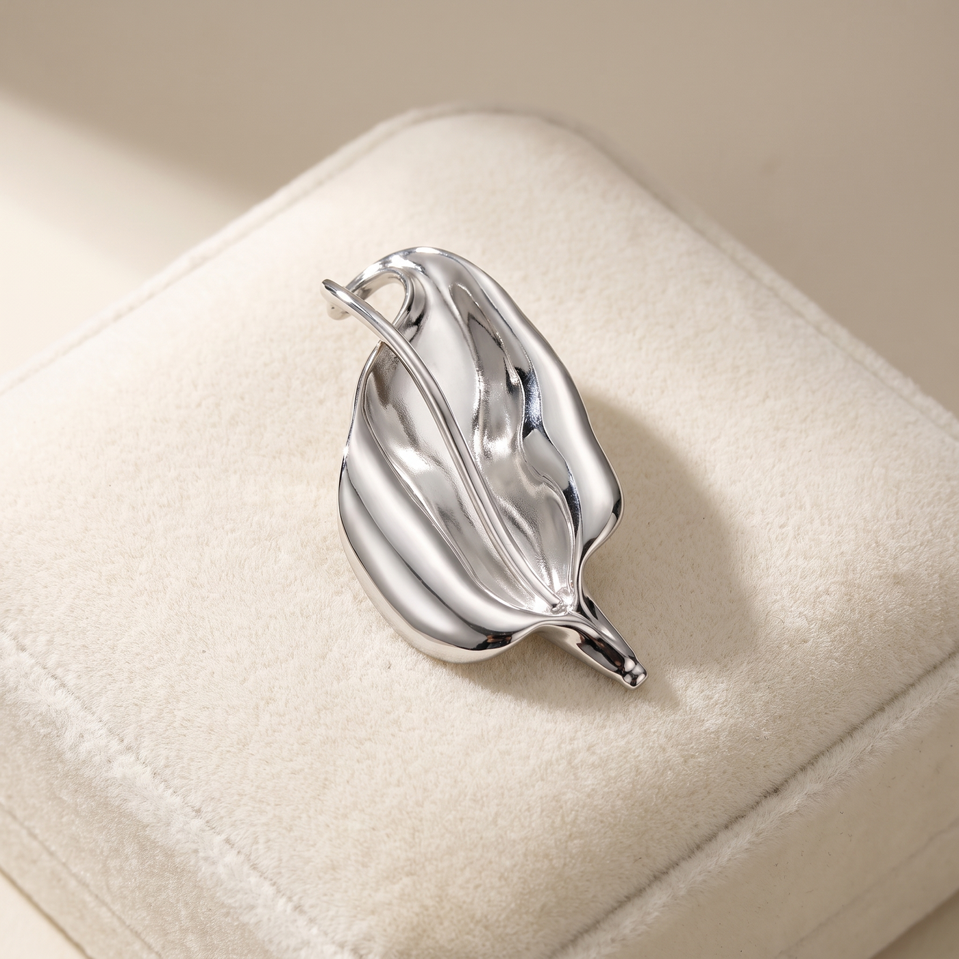 Broche Lys en acier, bijou vintage Alyvoa présentée sur un coussin · Argenté