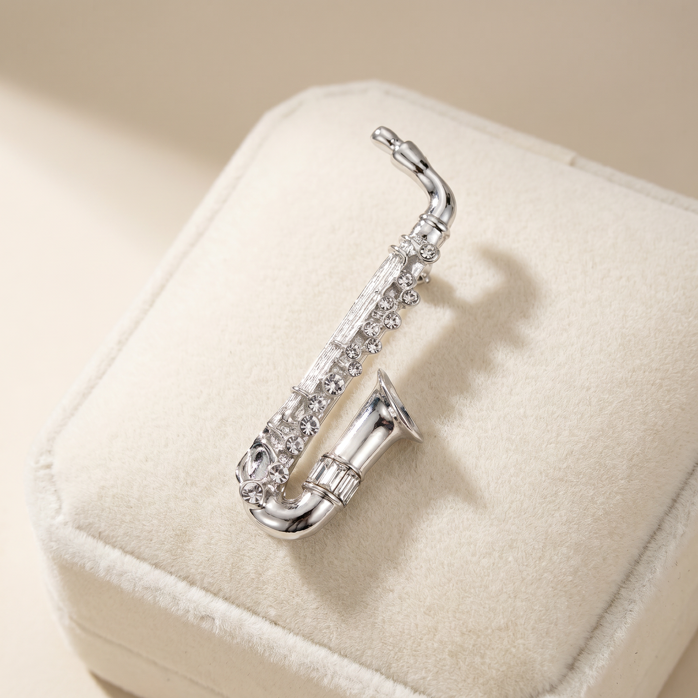 Broche Saxophone en cristal, bijou vintage Alyvoa présentée sur un coussin · Argenté