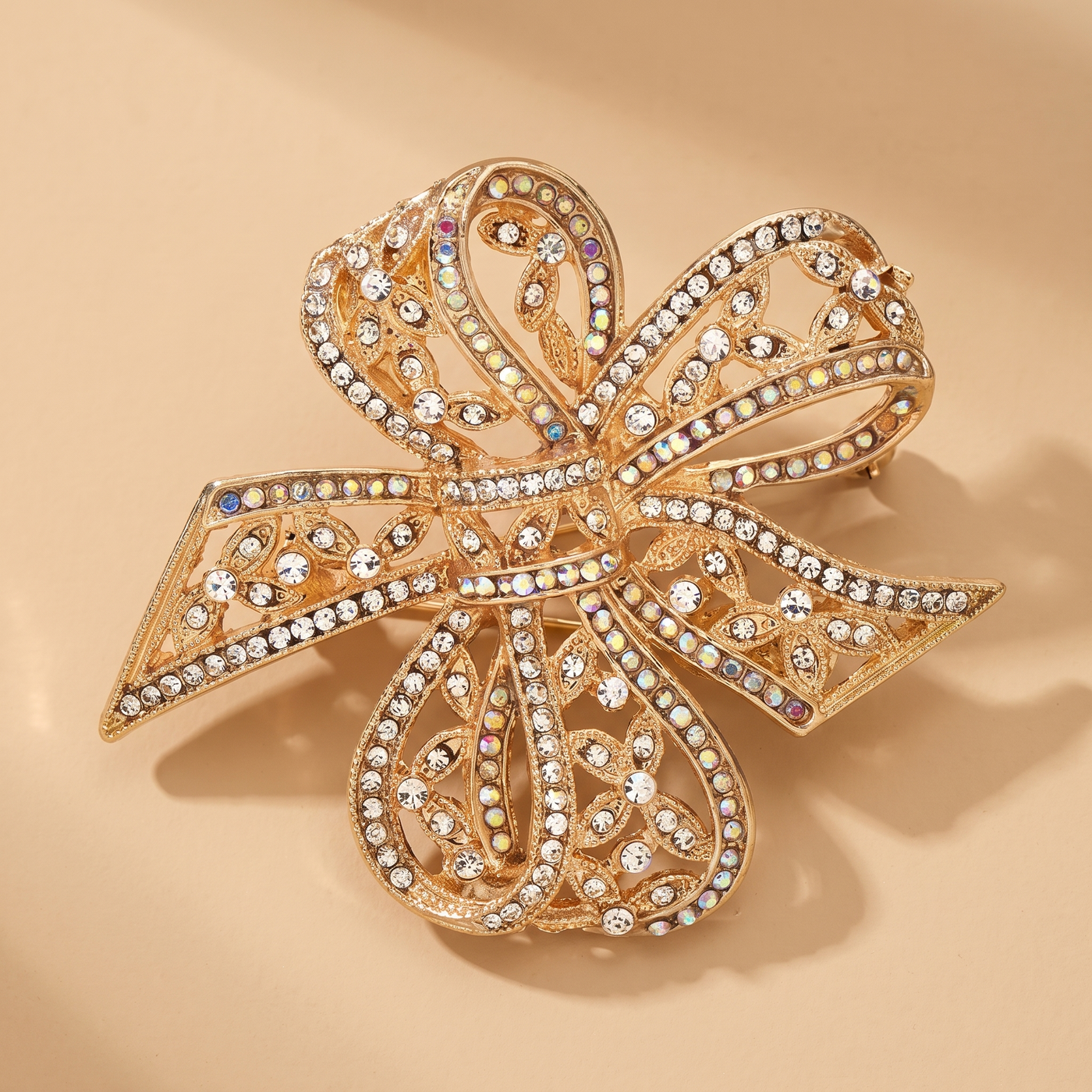 Broche Nœud en cristal, bijou vintage Alyvoa présentée sur un coussin · Doré