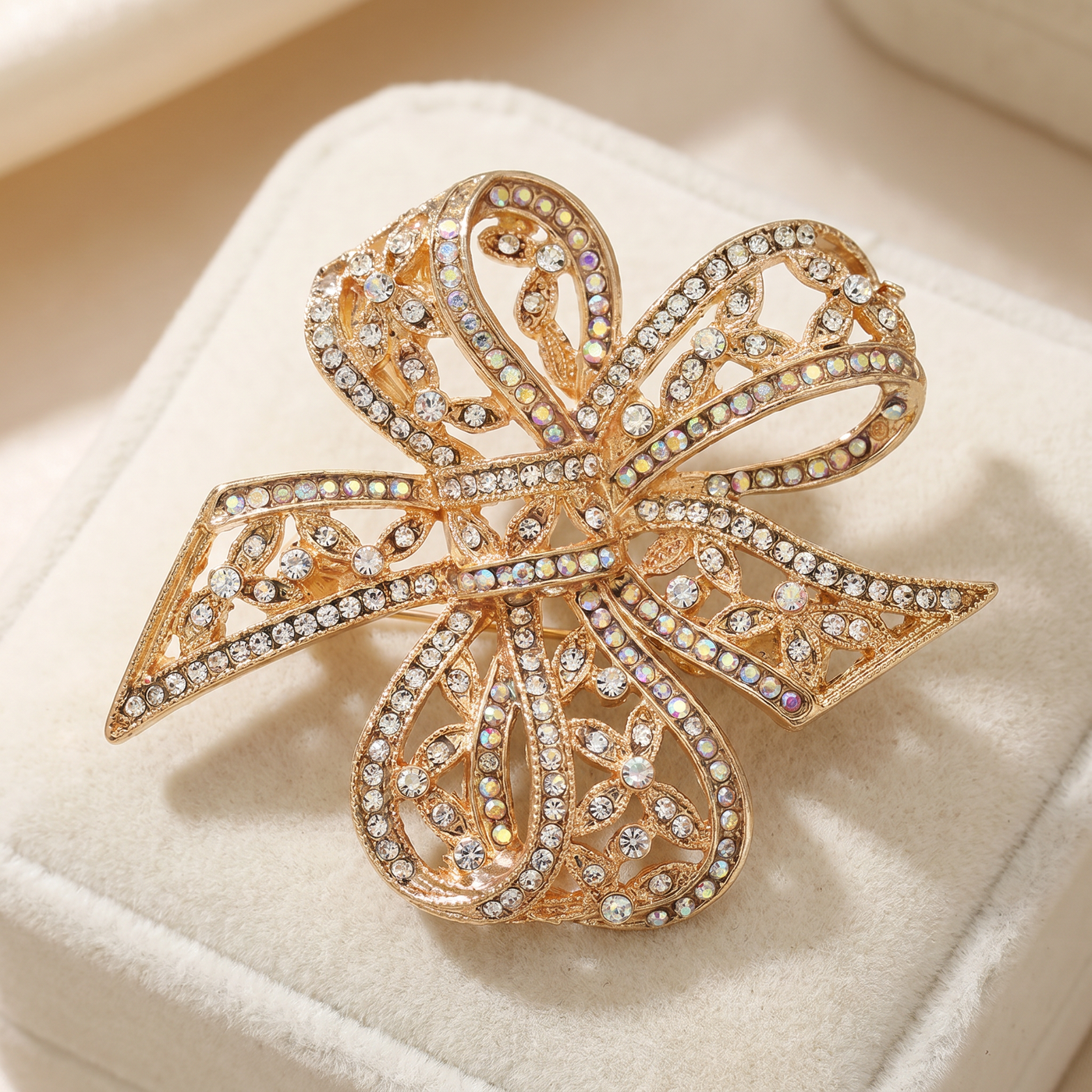 Broche Nœud en cristal, bijou vintage Alyvoa tenue à la main · Doré
