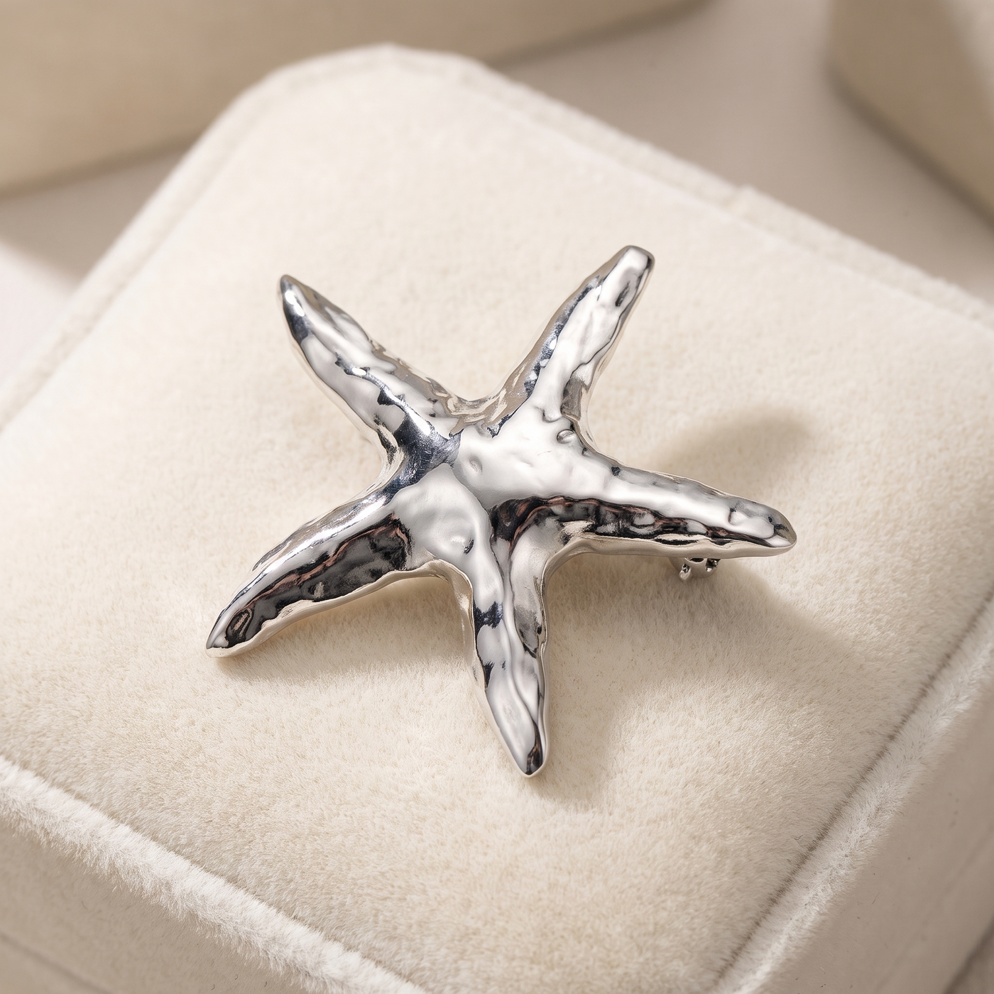 Broche Étoile de Mer en acier, bijou vintage Alyvoa présentée sur un coussin · Argenté