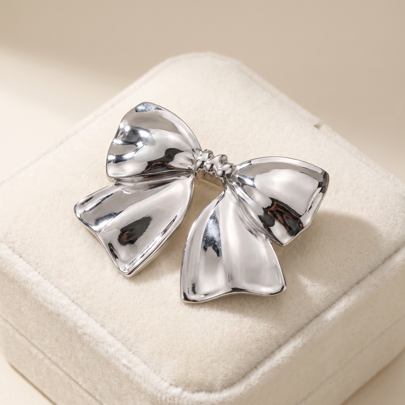 Broche Nœud en acier, bijou vintage Alyvoa présentée sur un coussin · Argenté