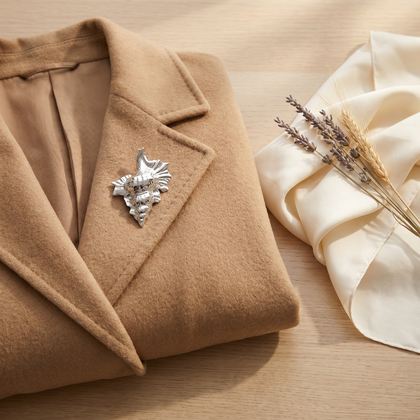 Broche Coquillage en acier, bijou vintage Alyvoa tenue à la main · Argenté