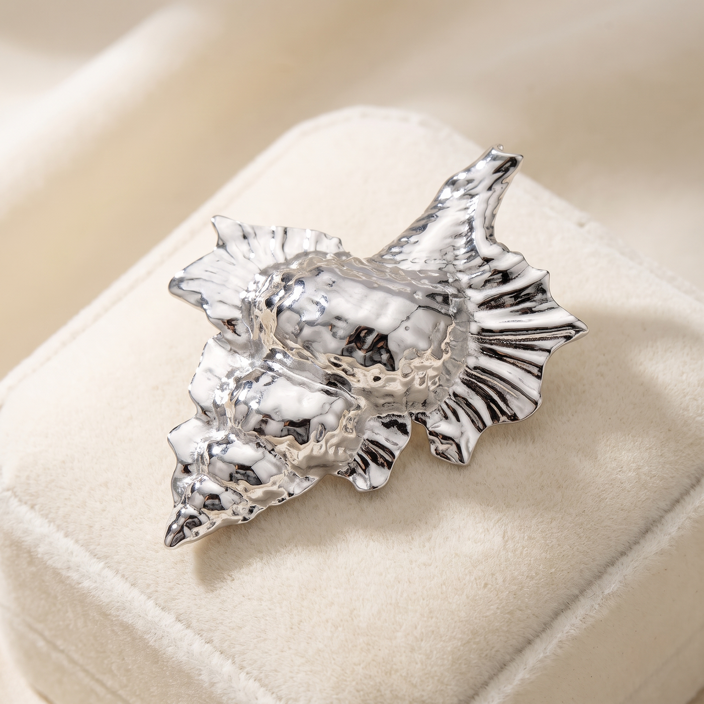 Broche Coquillage en acier, bijou vintage Alyvoa présentée sur un coussin · Argenté