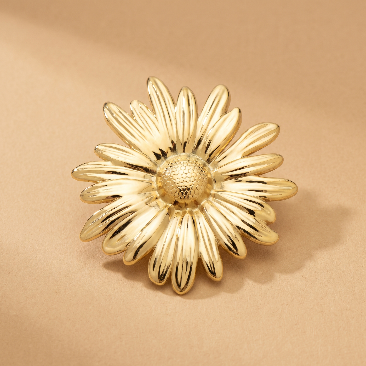 Broche Marguerite en acier, bijou vintage Alyvoa portée sur un revers · Doré