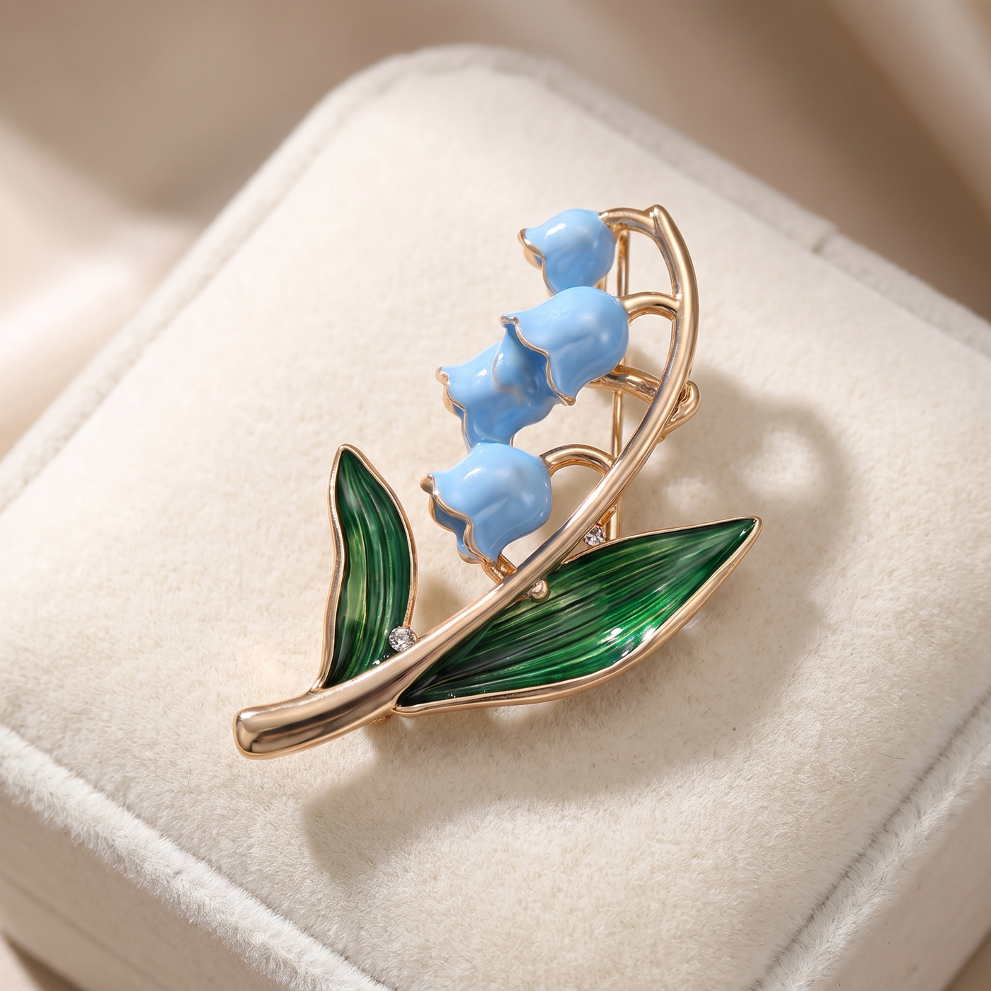 Broche Fleur en émail, bijou vintage Alyvoa tenue à la main · Muguet bleu