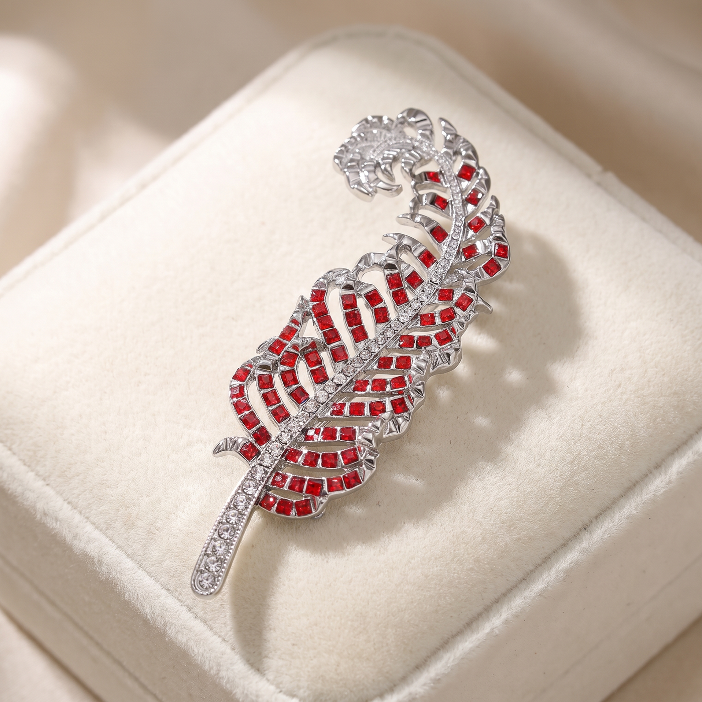 Broche Plume en cristal, bijou vintage Alyvoa présentée sur un coussin · Rouge