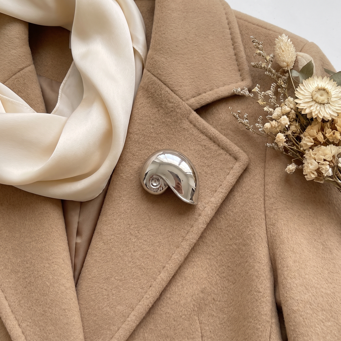 Broche Coquillage, bijou fantaisie vintage Alyvoa tenue à la main · Argenté