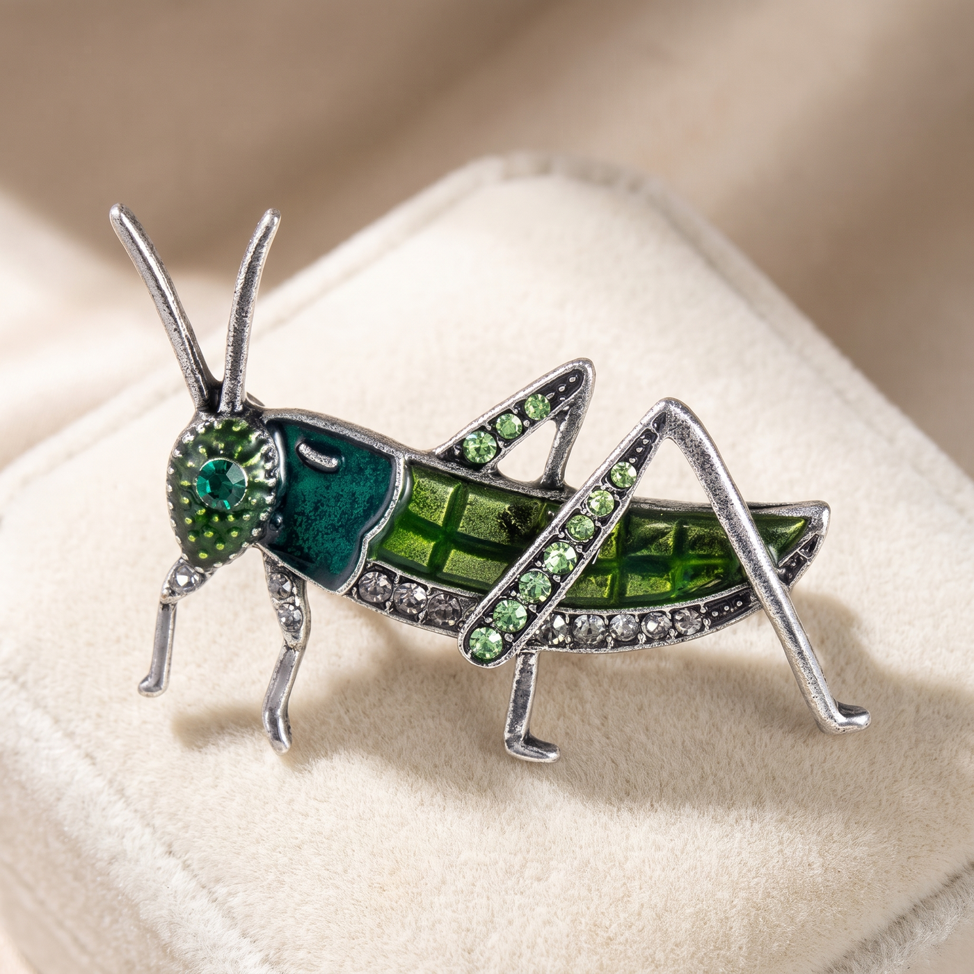 Broche Sauterelle en émail, bijou vintage Alyvoa tenue à la main