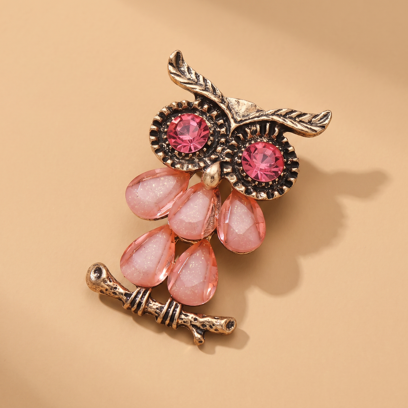 Broche Hibou, bijou fantaisie vintage Alyvoa tenue à la main · Rose