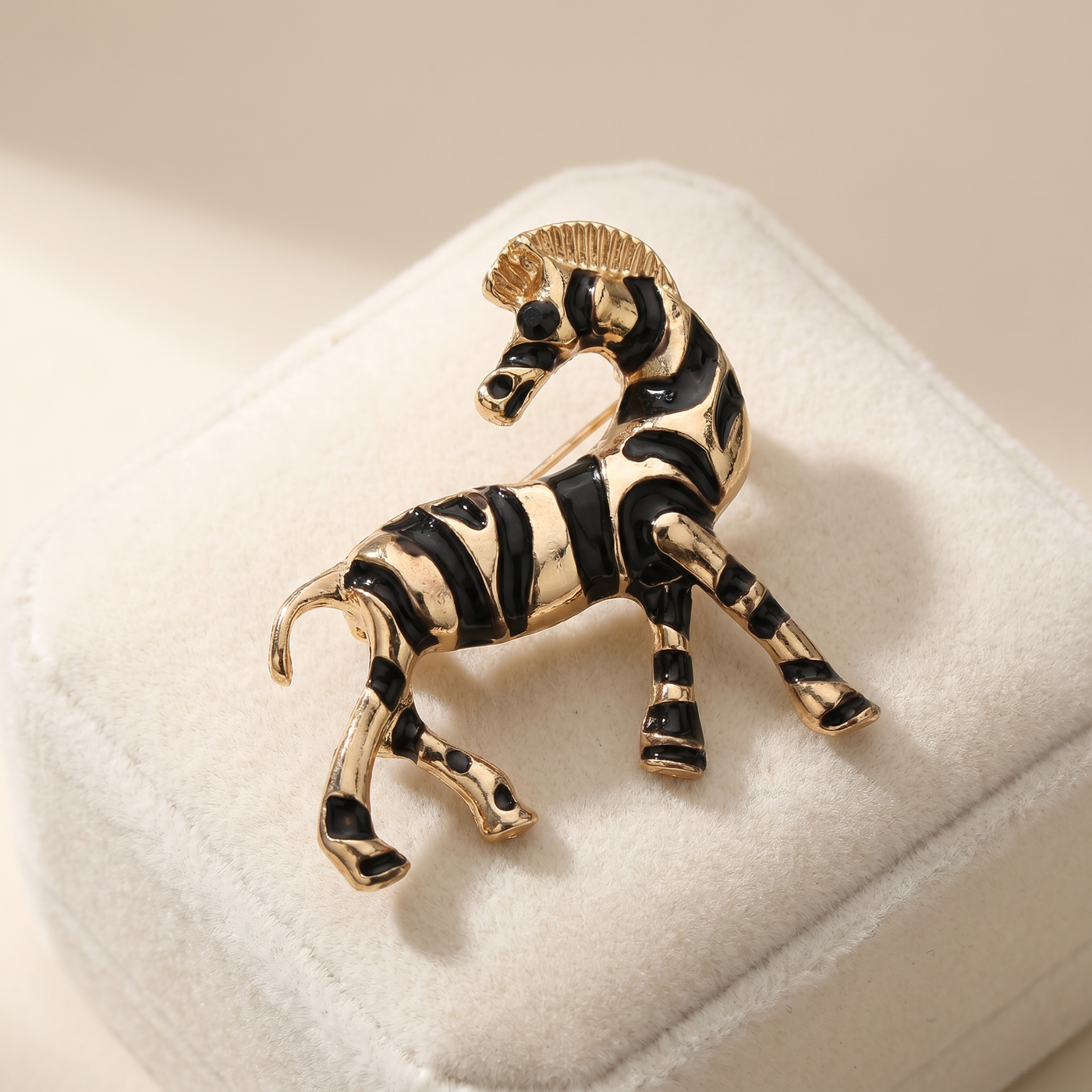 Broche Zèbre en émail, bijou vintage Alyvoa présentée sur un coussin · Noir