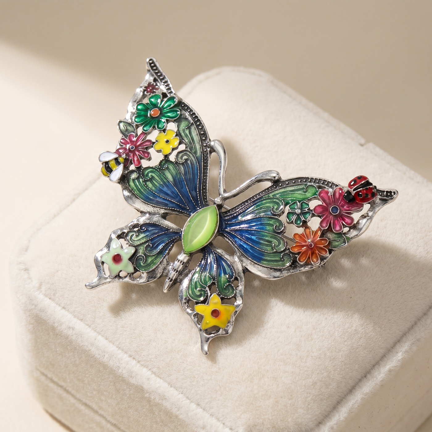 Broche Papillon en émail, bijou vintage Alyvoa présentée sur un coussin · Vert