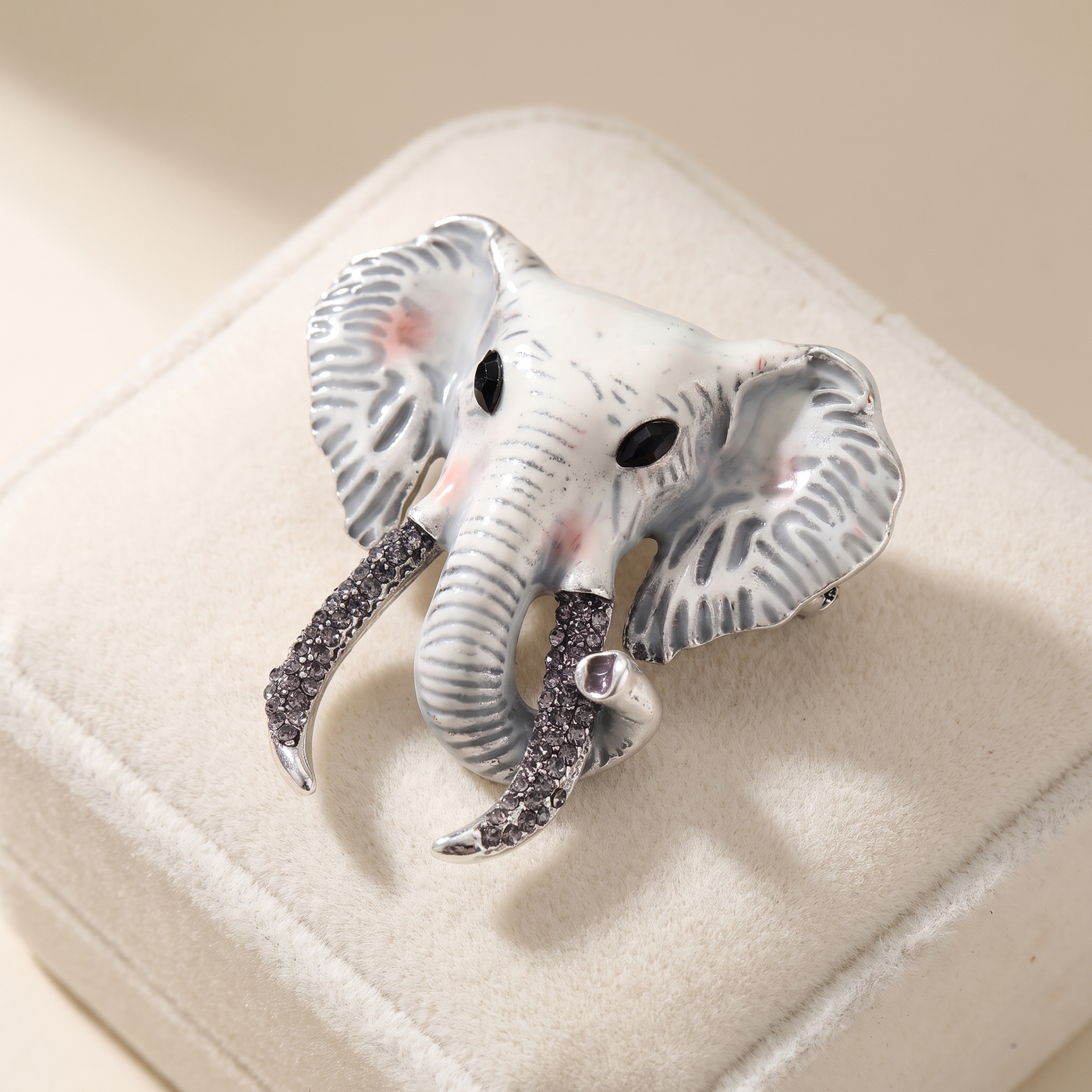 Broche Éléphant en émail, bijou vintage Alyvoa présentée sur un coussin · Blanc