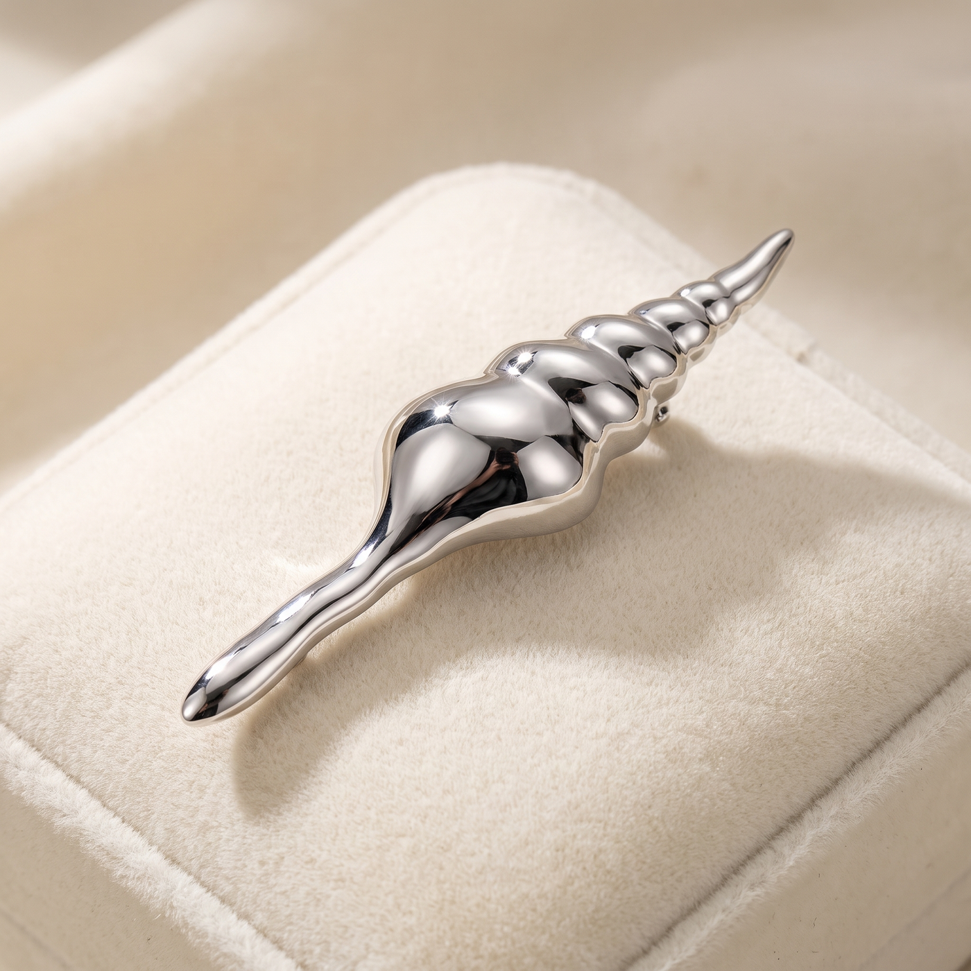 Broche Coquillage en acier, bijou vintage Alyvoa présentée sur un coussin · Argenté