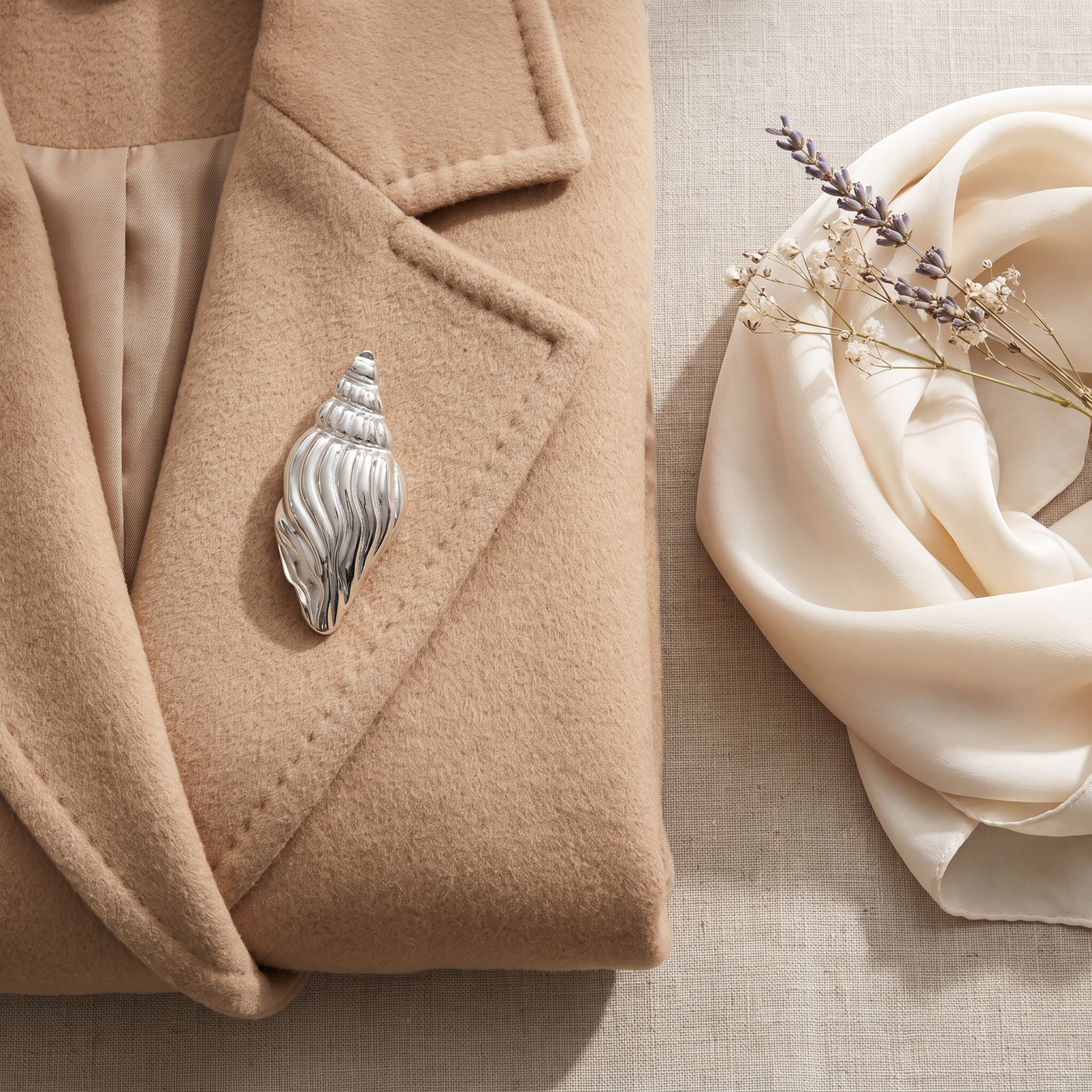 Broche Coquillage en acier, bijou vintage Alyvoa tenue à la main · Argenté