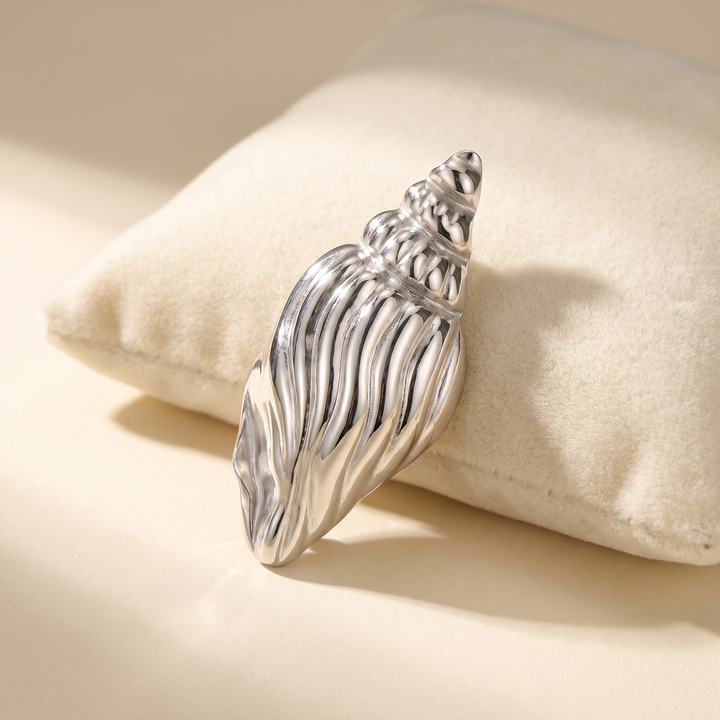 Broche Coquillage en acier, bijou vintage Alyvoa présentée sur un coussin · Argenté