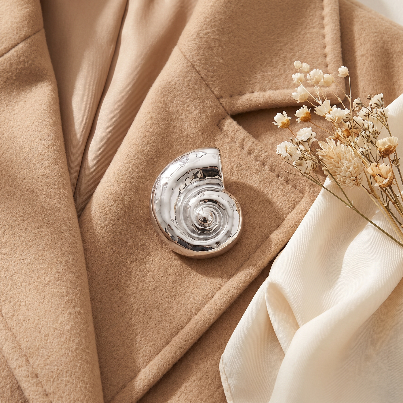 Broche Coquillage en acier, bijou vintage Alyvoa tenue à la main · Argenté