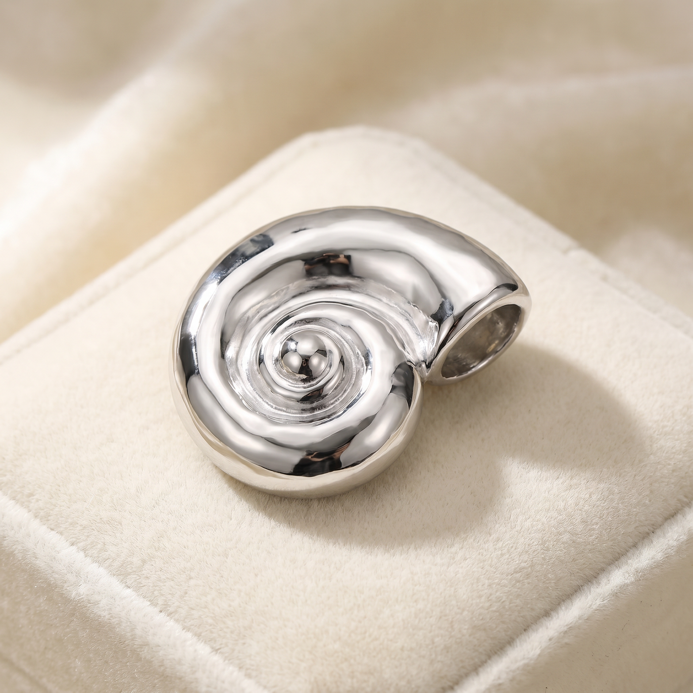 Broche Coquillage en acier, bijou vintage Alyvoa présentée sur un coussin · Argenté