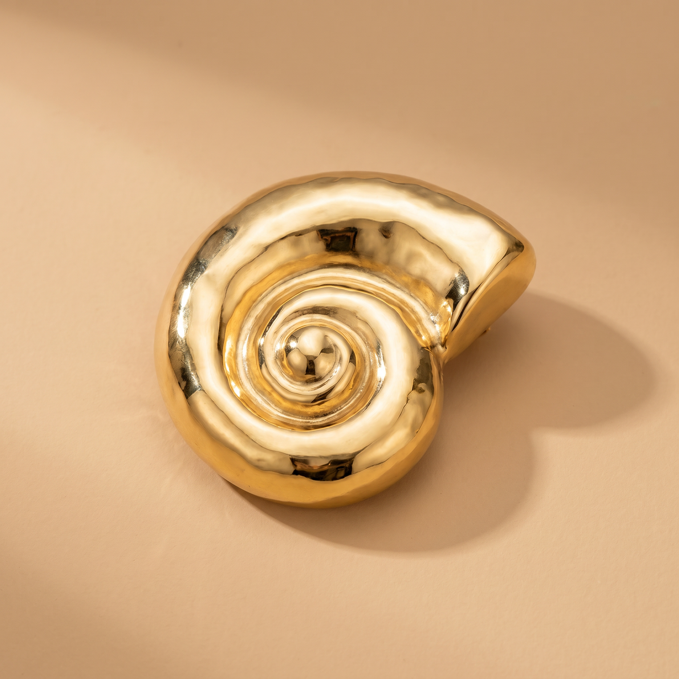 Broche Coquillage en acier, bijou vintage Alyvoa portée sur un revers · Doré