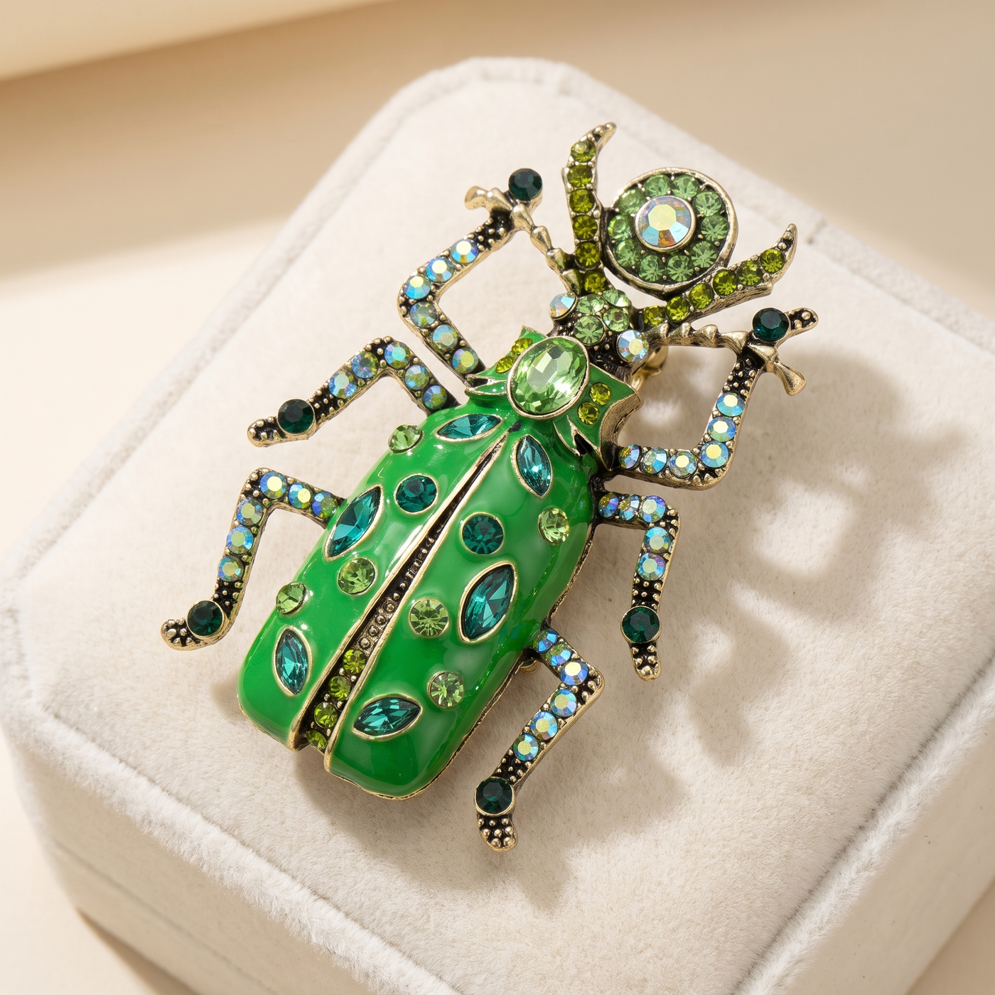Broche Scarabée en cristal, bijou vintage Alyvoa présentée sur un coussin · Vert