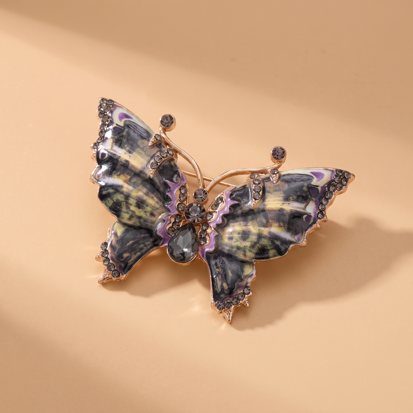 Broche Papillon en émail, bijou vintage Alyvoa tenue à la main · Gris